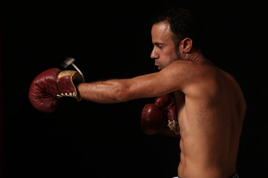 Man boxing over dark background
