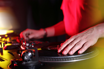 Dłonie didżeja miksującego muzykę podczas imprezy w klubie