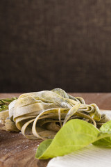Fresh Pasta Raw spinach fresh pasta tagliatelle decor with fresh spinach on background