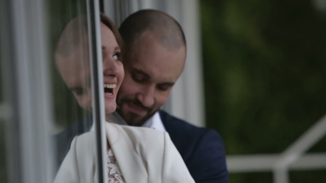 Family couple on veranda of their home