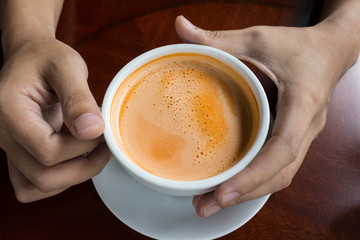 hand holding a cup of coffee hot drink design