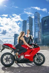 Foto op Plexiglas Young couple on a sports bike on the background of the city skyl © Andrey_Arkusha