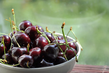 Fresh cherries in bowl on table