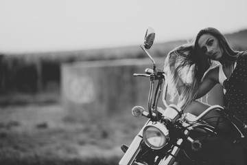 Fototapeta na wymiar Beautiful woman on the motorcycle. Retro Black and white filter.