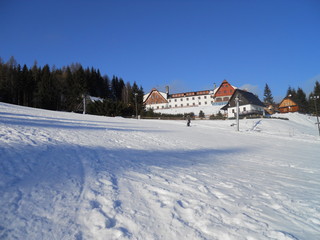 Snowy slope with a mountain chalet