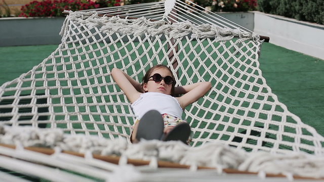Female child relaxing outdoors in a hammock