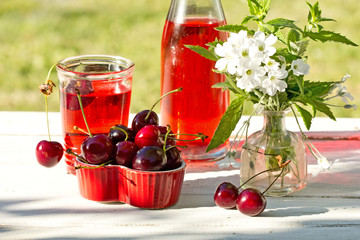 sweet cherries  in a heart box on wooden table in the garden