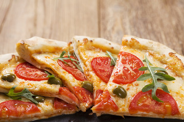 Pizza vegetarian on plate on stone black try with fresh tomatoes