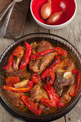 Pork baked with peppers, tomatoes and onion.