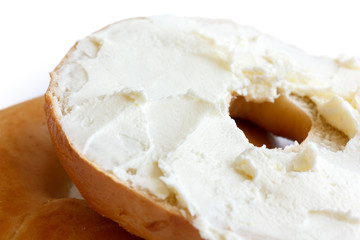 Fototapeta na wymiar Plain bagel cut in half and spread with cream cheese, detail.