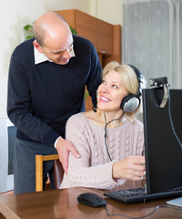 Senior couple using PC at home