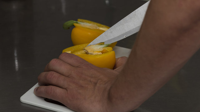 A man clearing a pepper from the seeds