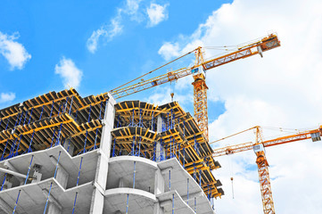 Crane and building construction site against blue sky