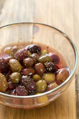 olives in dish on brown wooden background