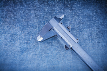 Stainless trammel caliper on scratched vintage metallic backgrou