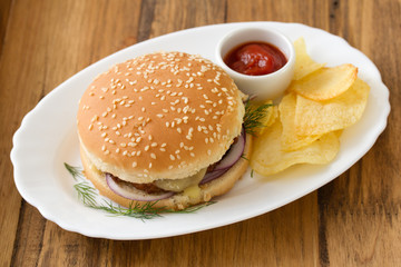 hamburger with chips and sauce on dish