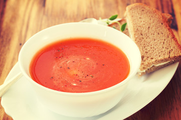 cold tomato soup in brown wooden background