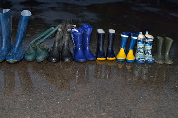 Several pairs of rubber boots, of a family that lives on a farm.
