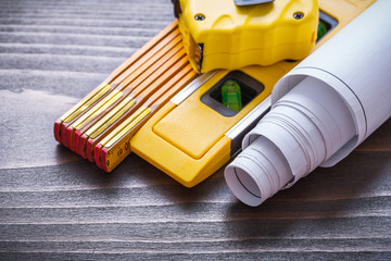 Tape-measure blueprints construction level and wooden meter on v