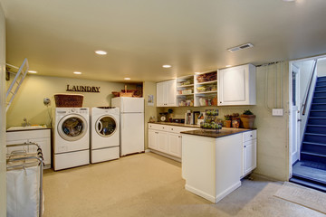 Large laundry room with appliances and cabinets.