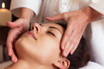 Fototapeta na wymiar Face Massage. Close-up of a beautiful Woman Getting Spa Treatmen