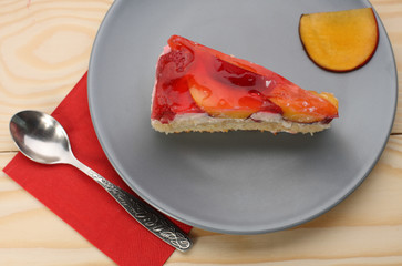 Strawberry and peach cake with gelatin on grey plate on wooden t