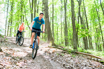 Naklejka premium Paar auf Mountainbike Fahrrad am Berg im Wald