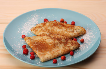 pancakes with wild strawberries   on blue plate