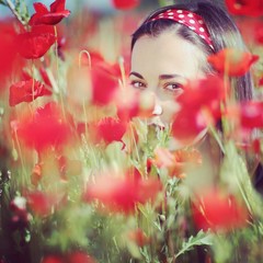 Young woman in the poppy meadow