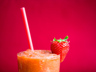 Strawberry smoothie in glass with straw - detail
