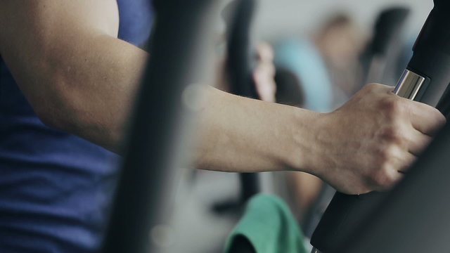 Man at the gym exercising on the strainer machine. Close up