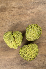 Some Sugar-Apples over a wooden table. Atemóia