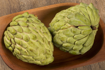 Some Sugar-Apples over a wooden table. Atemóia