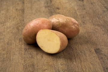 Fototapeta na wymiar Fresh potatoes on rustic wooden background