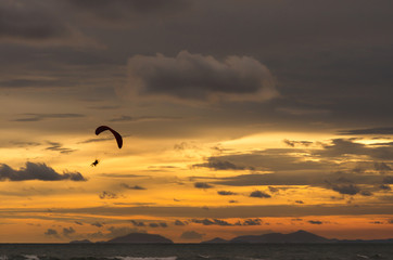 Fototapeta na wymiar Silhouette of flying paramotor at sunset.