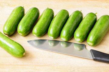 little cucumbers on the wooden board