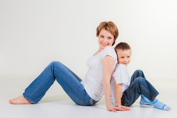 Mother with her little son sitting back to back