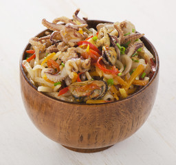 Delicious rice noodles with seafood closeup in a bowl.
