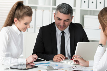 Adult businessman consulting his young female colleague