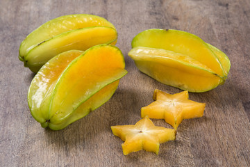 Some caramboles in a basket over a wooden surface