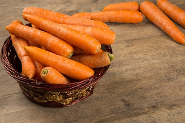 Fresh carrot with green leaves on wooden table