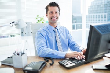 Fototapeta premium Smiling businessman using computer 