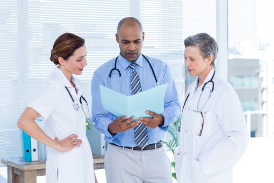 Concentrated medical colleagues analyzing file together