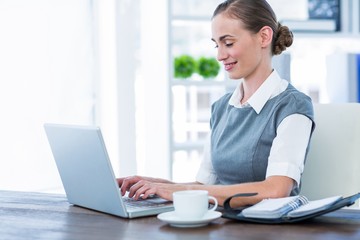 Happy businesswoman working on laptop computer 
