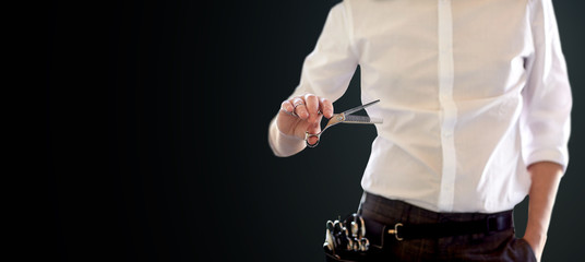 close up of male stylist with scissors over black