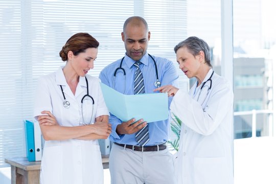 Concentrated medical colleagues analyzing file together