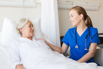 doctor or nurse visiting senior woman at hospital