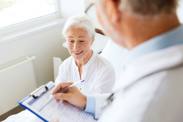 senior woman and doctor with clipboard at hospital