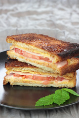 Closeup of halved ham and swiss cheese toast.