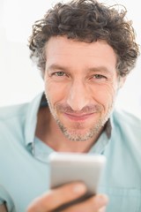  Smiling casual businessman sending a text 